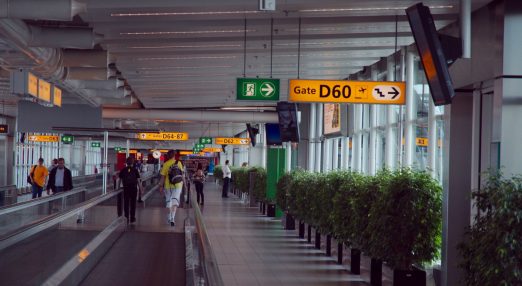 An image showing an airport terminal with people walking.