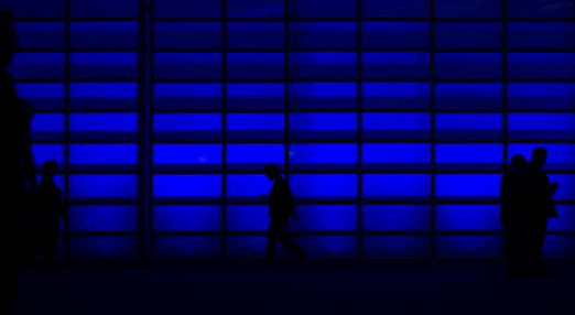 A person passing by a blue wall