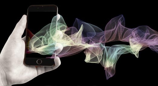 An image showing abstract textures exiting the screen of a phone held by a hand.