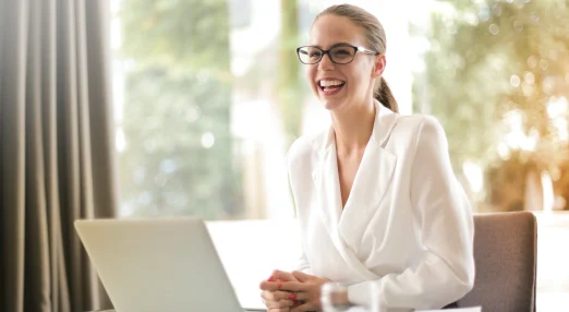 aughing businesswoman working in office with laptop