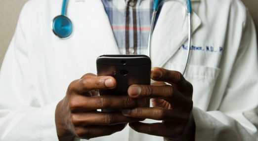 A doctor looking at a phone