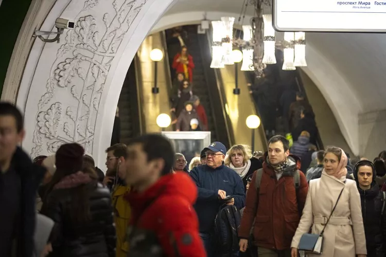 A surveillance camera is seen as people walk down in a Moscow's Metro (subway) station in Moscow, February 2020